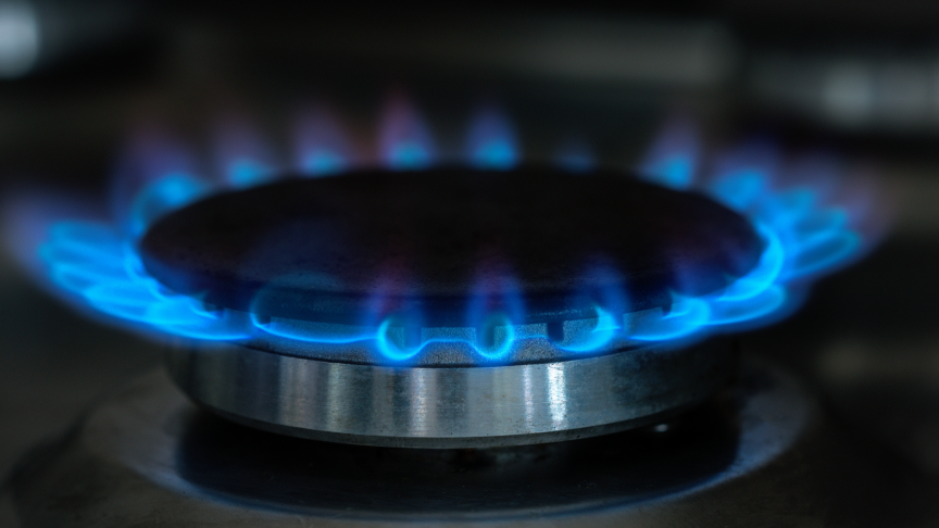 A lit gas hob with blue flames