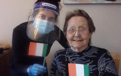 Jessica waves handmade Irish flags with resident, Elsie