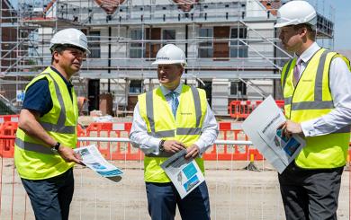Craig Moule, Nigel Huddleston and Mark Battin in high vis jackets standing in front of the Evesham development.
