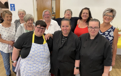 A group of women standing in a room smiling