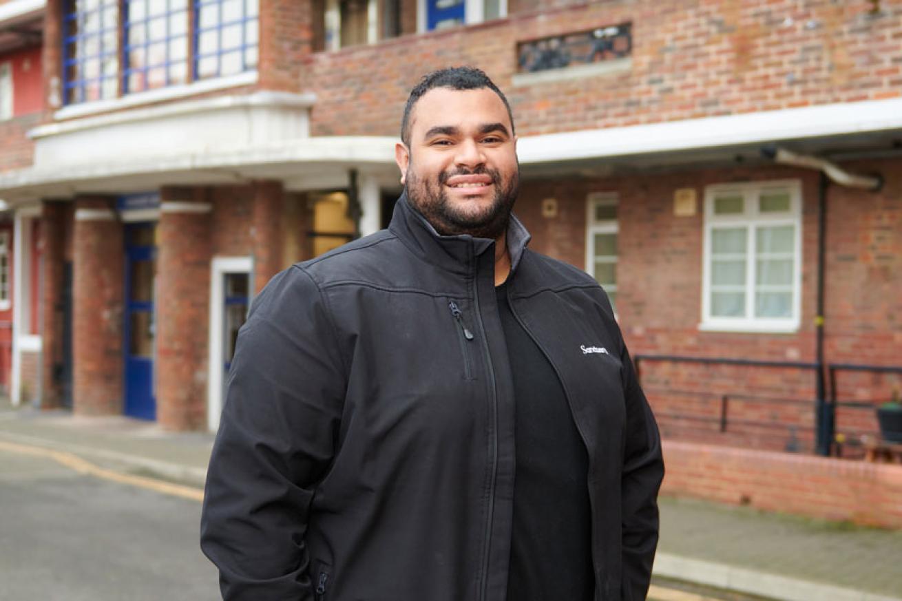 A Sanctuary housing officer stood outside a block of flats