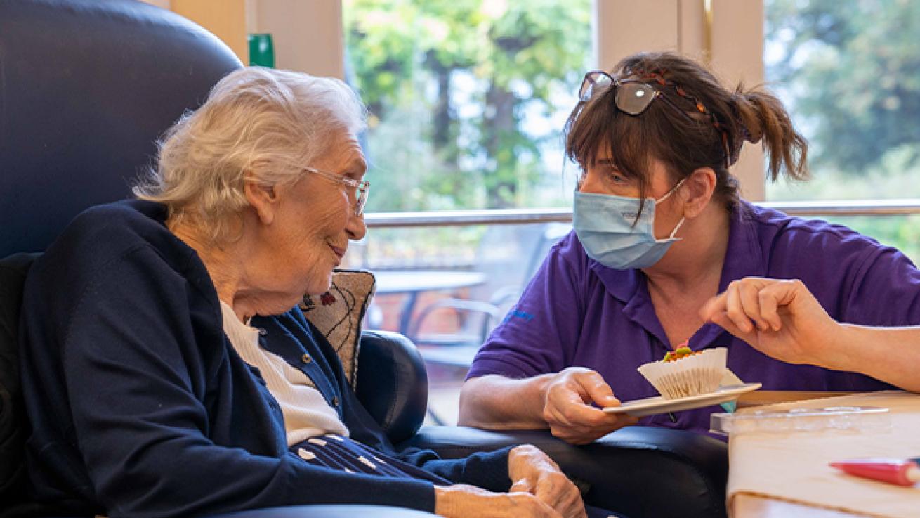 Sanctuary Care staff talking with a resident