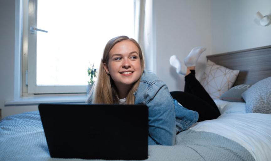 A student using their laptop in their bedroom A student using their laptop in their bedroom