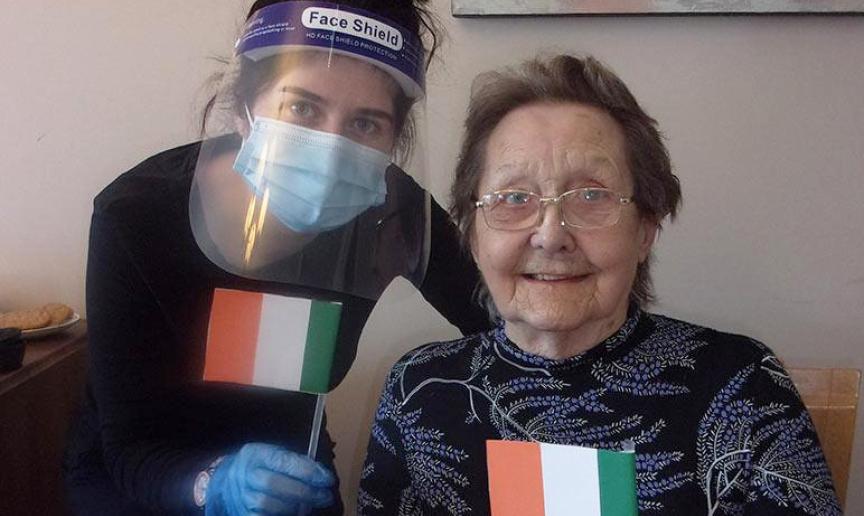 Jessica waves handmade Irish flags with resident, Elsie