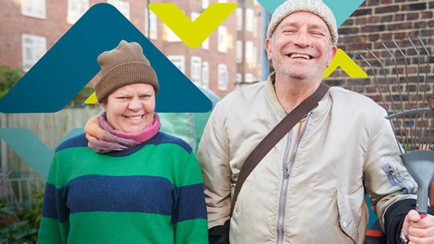 Two residents smiling, standing in an allotment